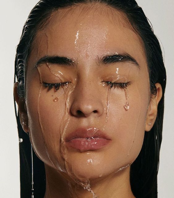 mujer cayéndole agua por la cara