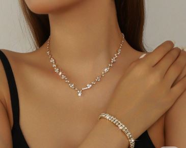 Accesorios de graduación, collar y pulsera de plata con brillantinas deslumbrantes, encima del cuello de una mujer