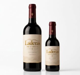 Fotografía de producto de dos botellas de vino tinto 'Laderas de Cangas' DOP Cangas, una de 750 ml y otra más pequeña de 250 ml, presentadas juntas sobre una superficie de madera y una peana beige con fondo claro, mostrando su etiqueta beige y cápsula granate.